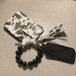 Black-and-white cow printed beaded wristlet with accessories ￼